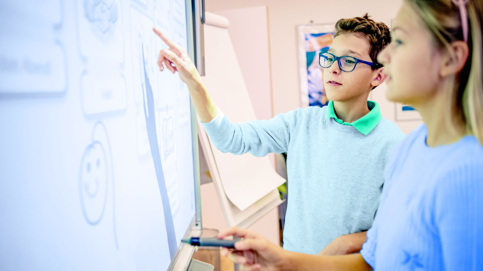 School friends working together on a project using a SMART board