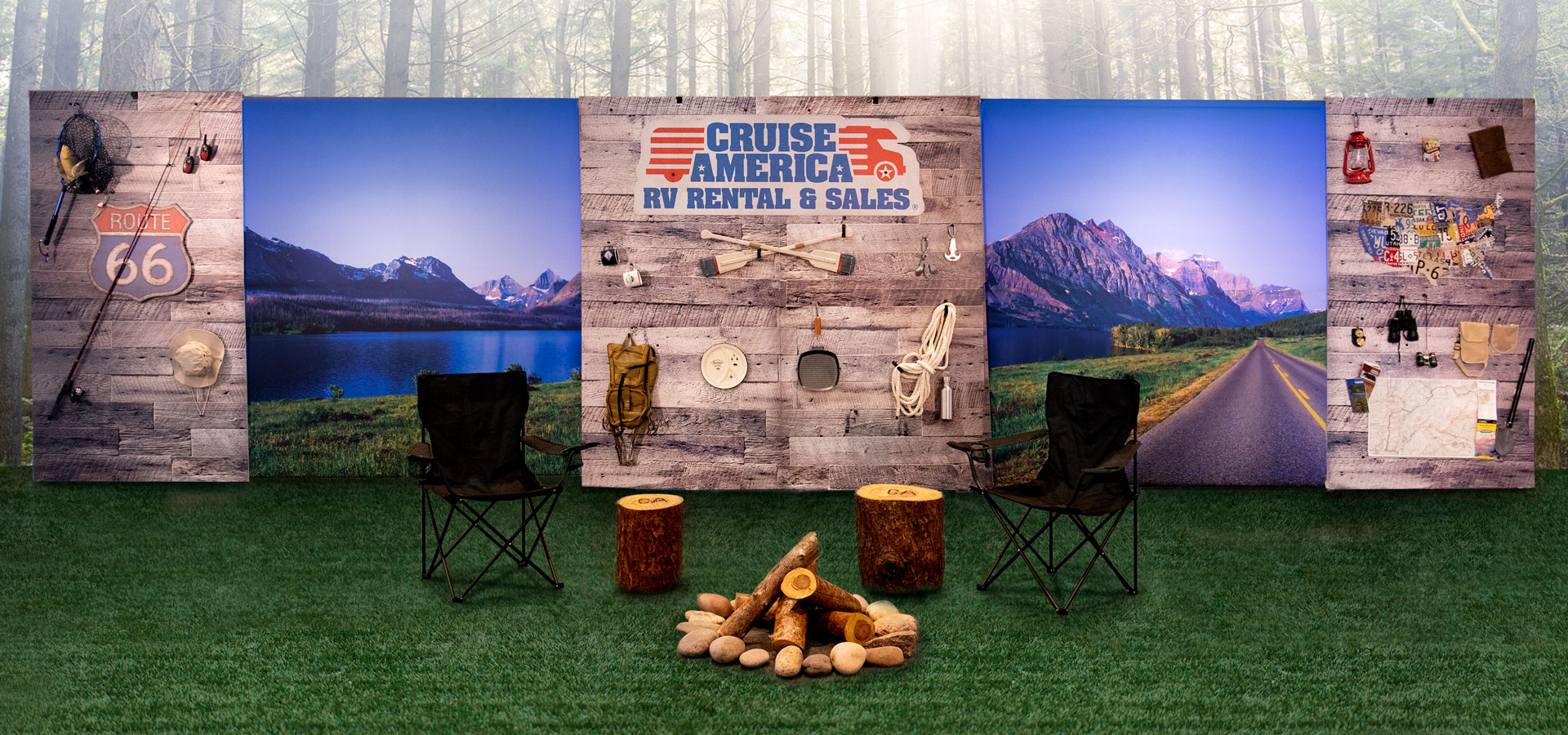 Tradeshow booth with camping gear adhered to a wood wall. With camping chairs around a firepit in front of the booth